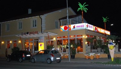 Die Muratti Gelateria in Gloggnitz am Abend mit beleuchtetem Schriftzug „Eissalon“ und Palmen