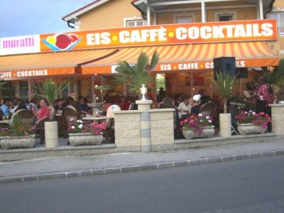 Gastgarten der Muratti Gelateria an der Wiener Straße mit Markise „Eis · Caffè · Cocktails“