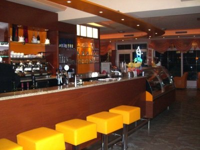 Bar mit gelben Barhockern und Eisvitrine