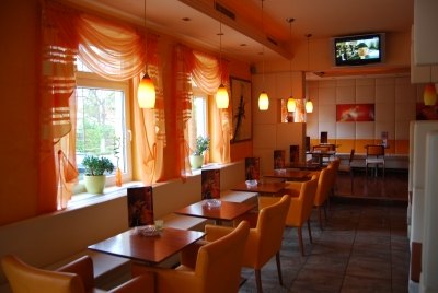 Café mit Tischen, Sitzbank und Fernseher