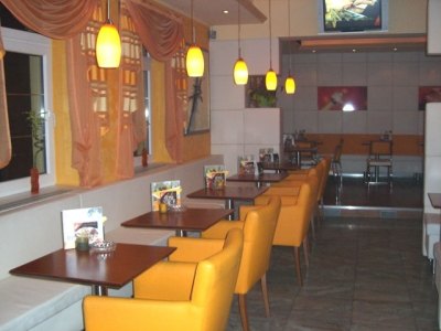 Café-Bereich mit orangen Ledersesseln und Hängeleuchten
