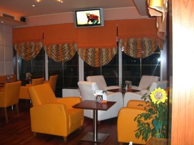 Lounge mit weißen Sofas und orangen Sesseln